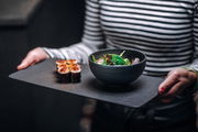 Schale Manufacture 200ml mit Salat, präsentiert auf einem Tablett aus der Perspektive einer Person, die es in den Händen hält.