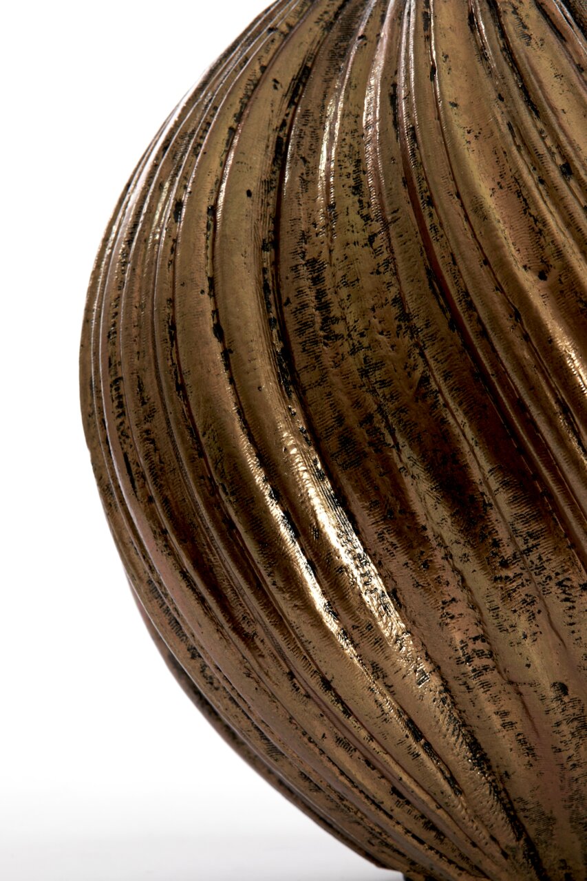 Nahaufnahme einer antik wirkenden Vase mit gerillter, bronzefarbener Oberfläche und patiniertem Finish, seitliche Perspektive.