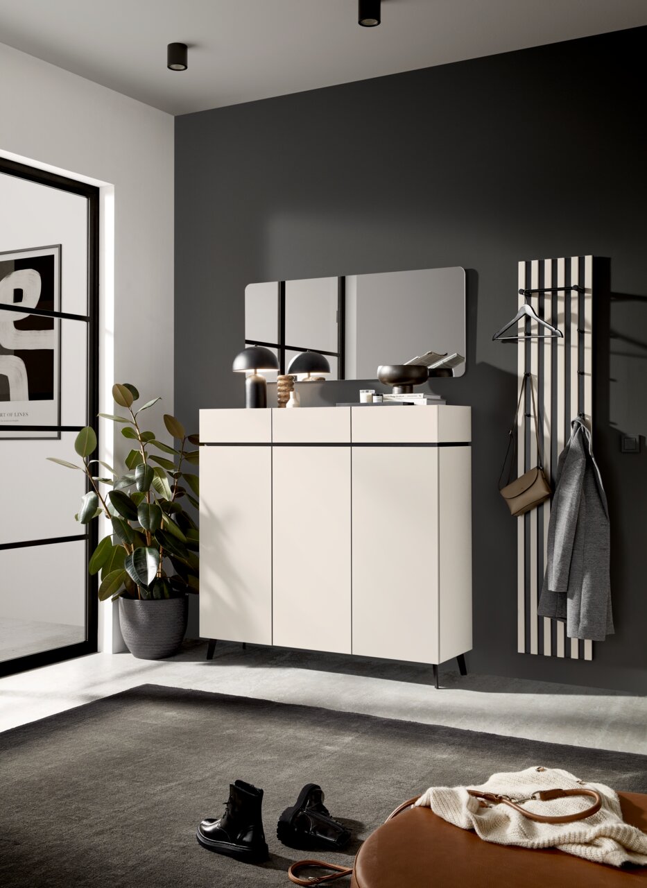 Voleo XL-Schuhschrank UNIQUE Moderner Eingangsbereich mit einem weißen Schuhschrank, einem rechteckigen Spiegel und einem Garderobenpaneel, seitliche Perspektive.