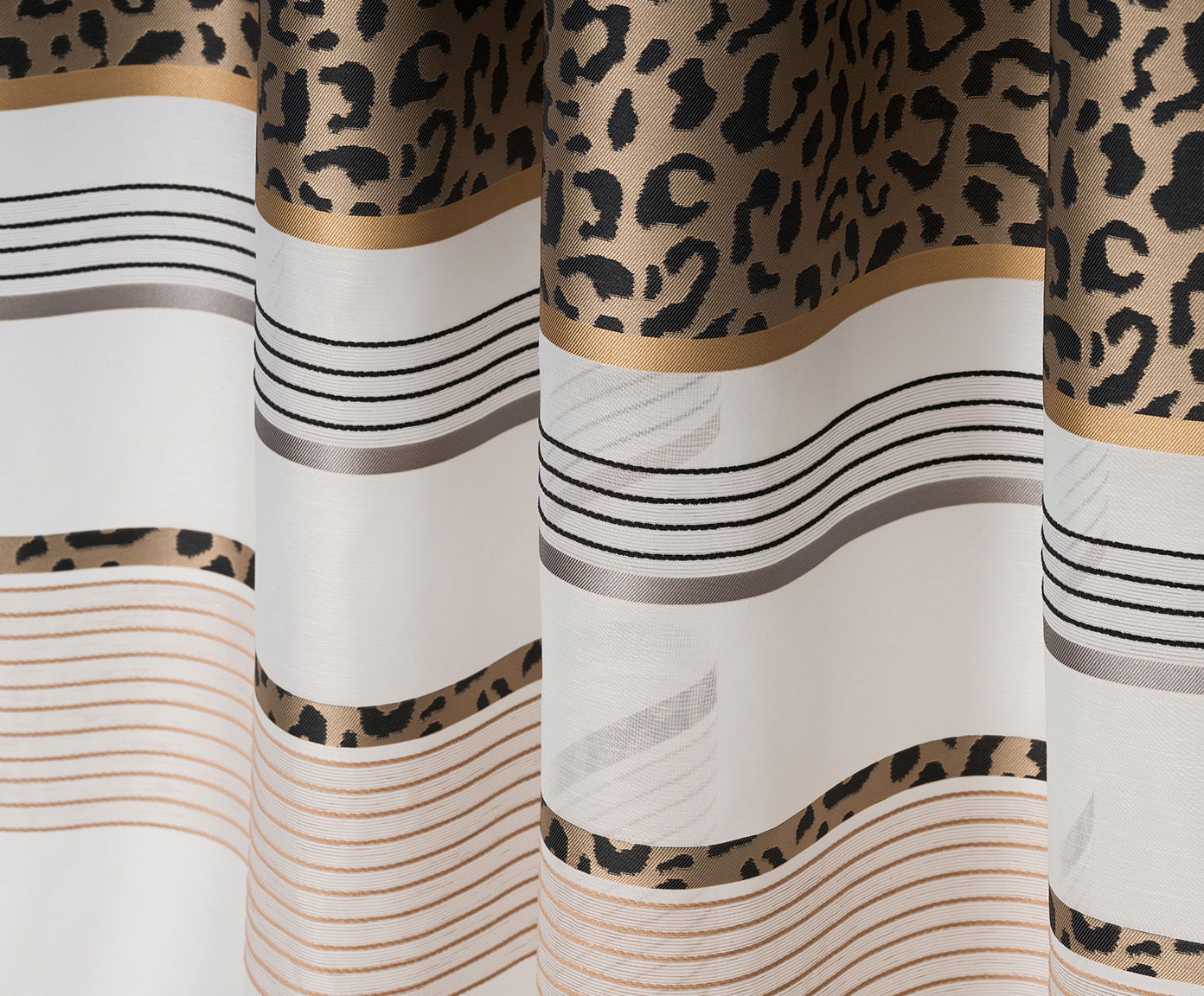 GÖZZE Schlaufenvorhang LEONA Nahaufnahme eines Schlaufenvorhangs mit Leopardenmuster und Streifen in Weiß, Schwarz und Gold.