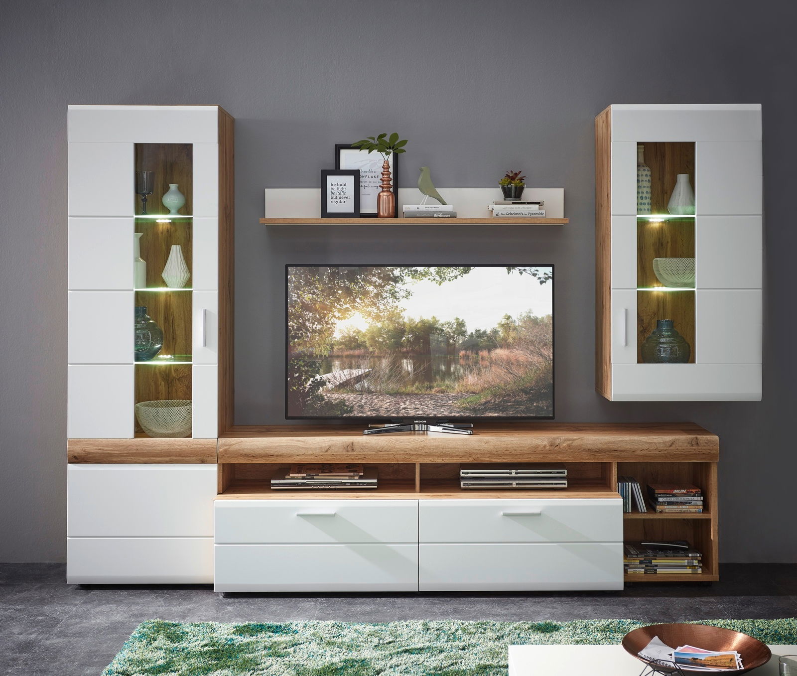 Moderne Wandkombination mit Holz- und Weißakzenten, bestehend aus zwei Vitrinen, einem TV-Schrank und einem Regal, frontal betrachtet.
