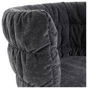 Nahaufnahme eines grauen, gepolsterten Armlehnstuhls mit weichem Stoffbezug, seitliche Perspektive.