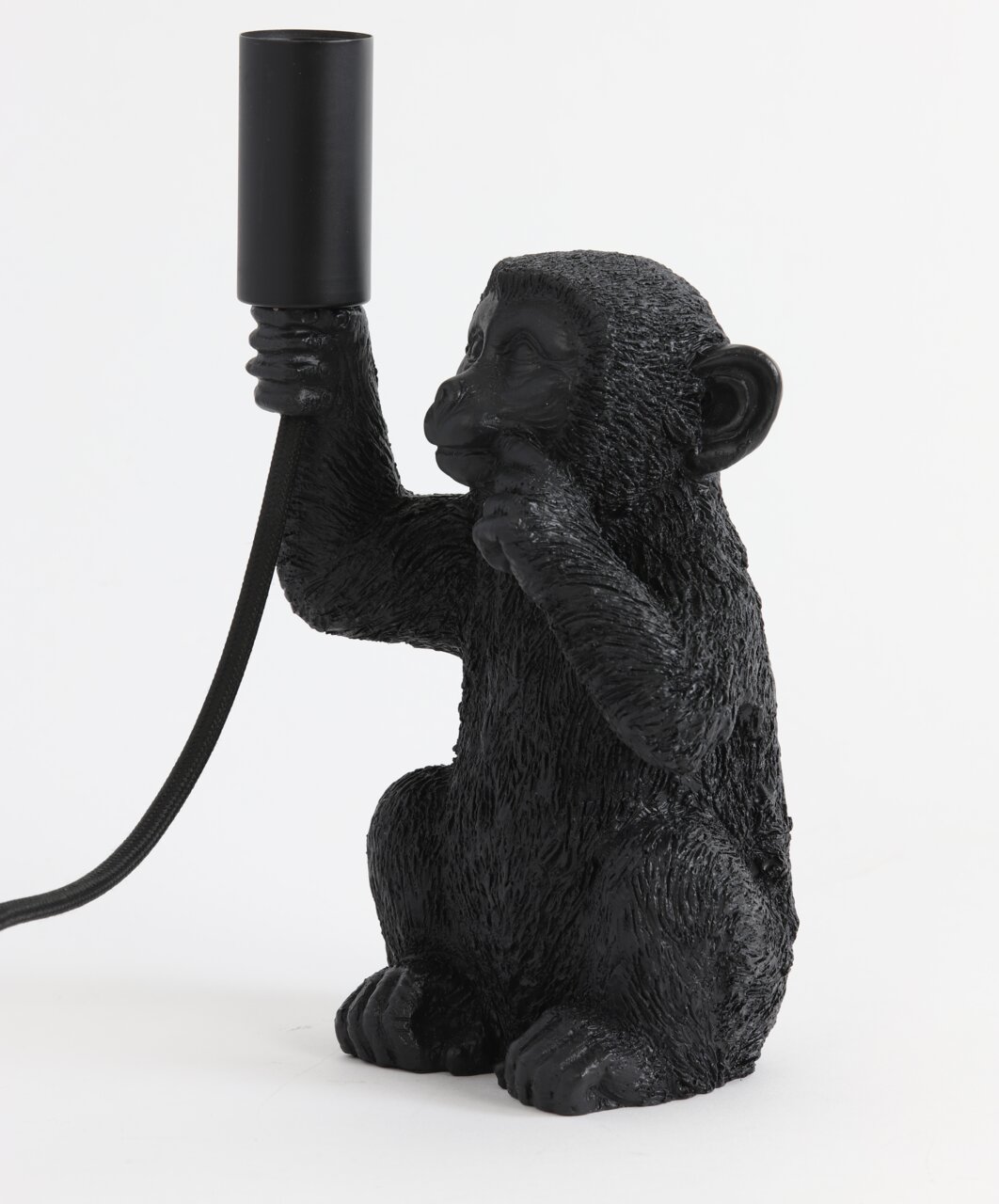 Schwarze Tischleuchte in Form eines Affen, der eine Lampenfassung in der Hand hält. Seitliche Perspektive.