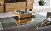 Moderner Couchtisch aus Holz mit rechteckiger Tischplatte und stabiler Mittelsäule, umgeben von gemütlichem Wohnzimmerambiente. Perspektive von schräg oben.