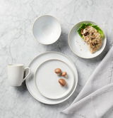 Kombiservice 20-tlg. aus Porzellan in eleganter Marmoroptik, bestehend aus Teller, Schüssel und Tasse, von oben fotografiert.