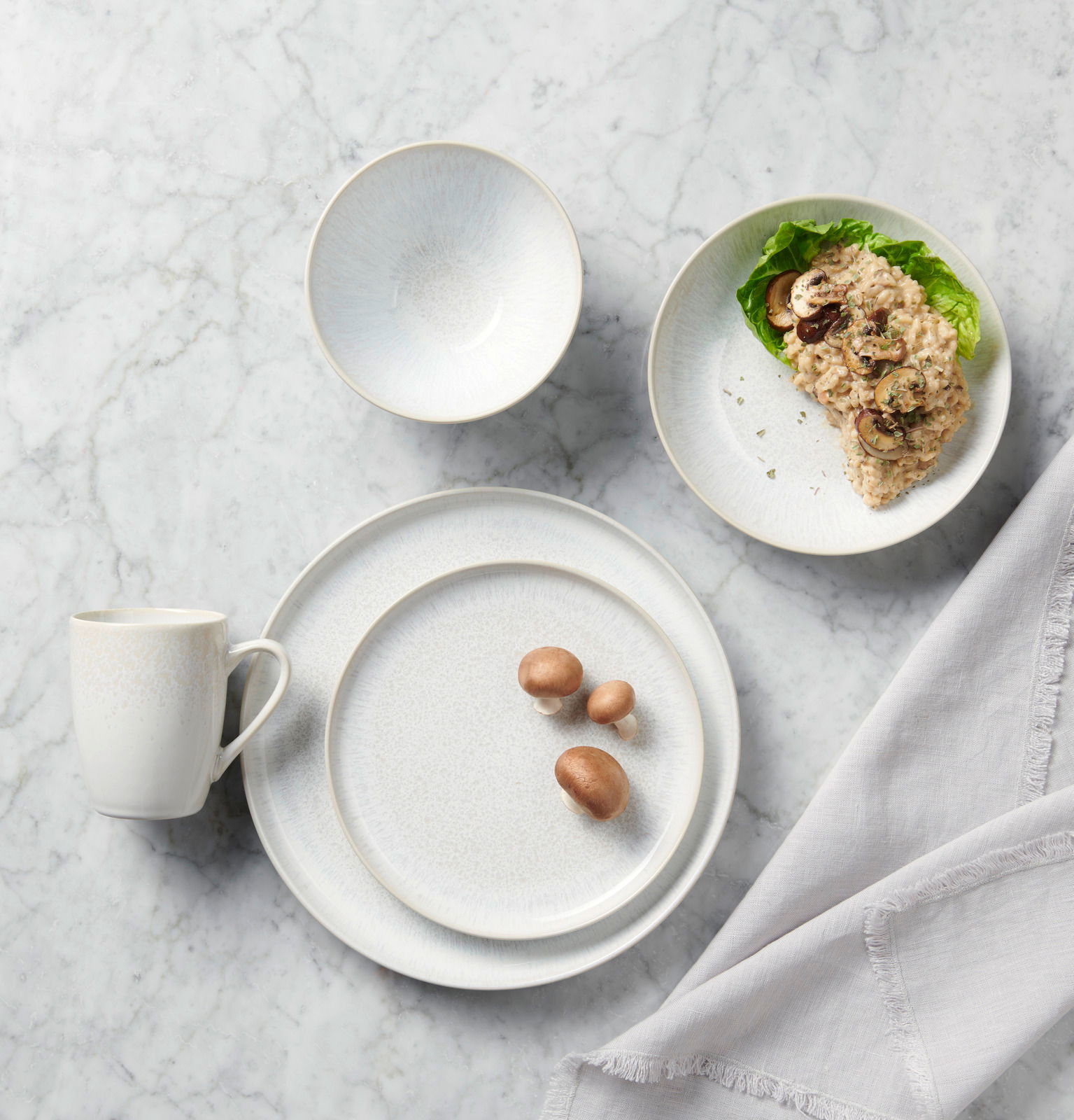 Kombiservice 20-tlg. aus Porzellan in eleganter Marmoroptik, bestehend aus Teller, Schüssel und Tasse, von oben fotografiert.