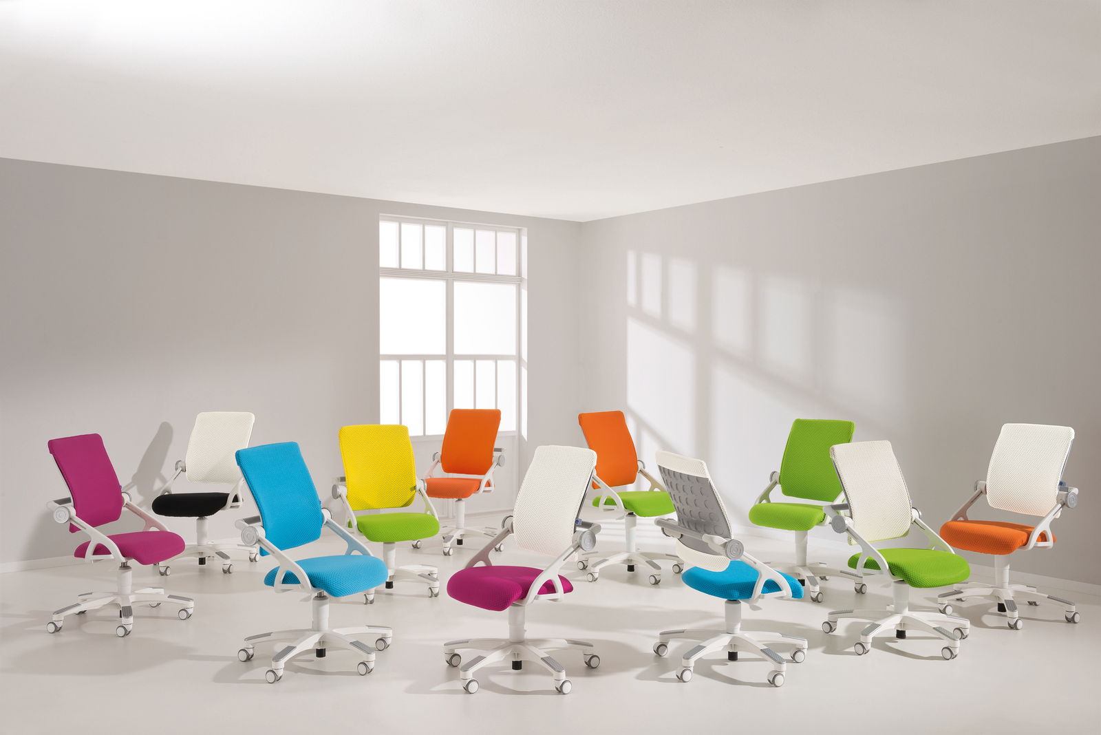 Mehrere bunte Drehstühle in einem hellen Raum, von der Seite betrachtet.