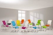 Mehrere bunte Drehstühle in einem hellen Raum, von der Seite betrachtet.
