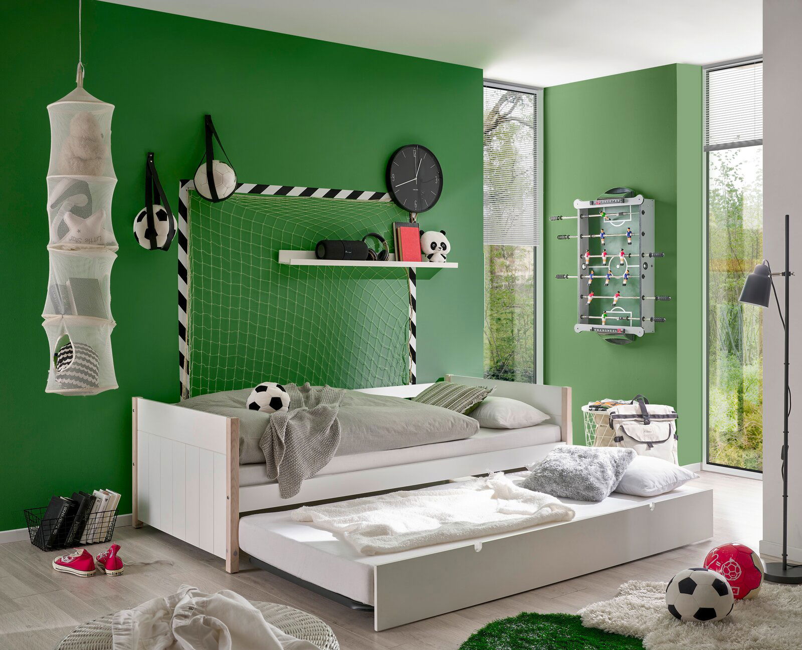 Jugendbett in einem sportlich dekorierten Zimmer mit Fußballmotiven, seitliche Perspektive