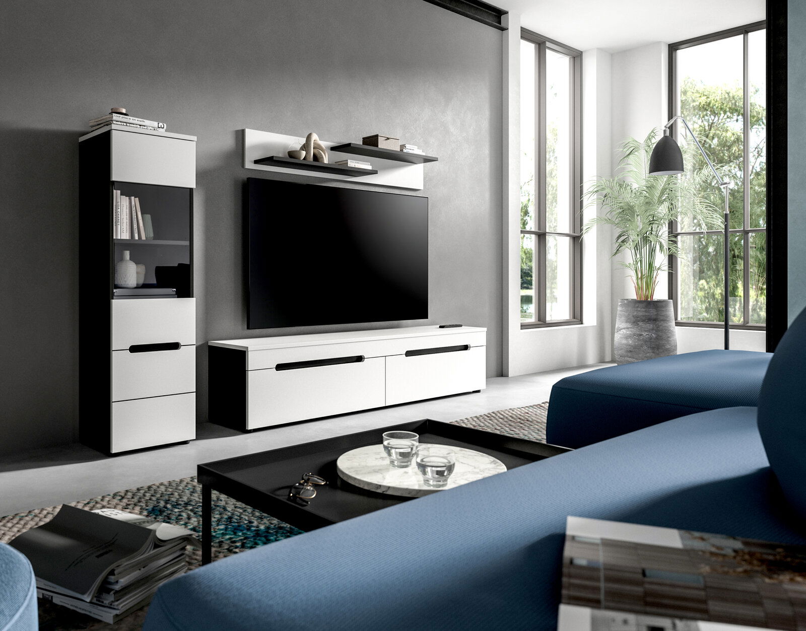 Modernes Wohnzimmer mit weißem TV-Lowboard und passendem Hochschrank, großem Flachbild-TV und Wandregal an grauer Wand, fotografiert aus schräger Frontansicht im hellen Raum mit großen Fenstern.