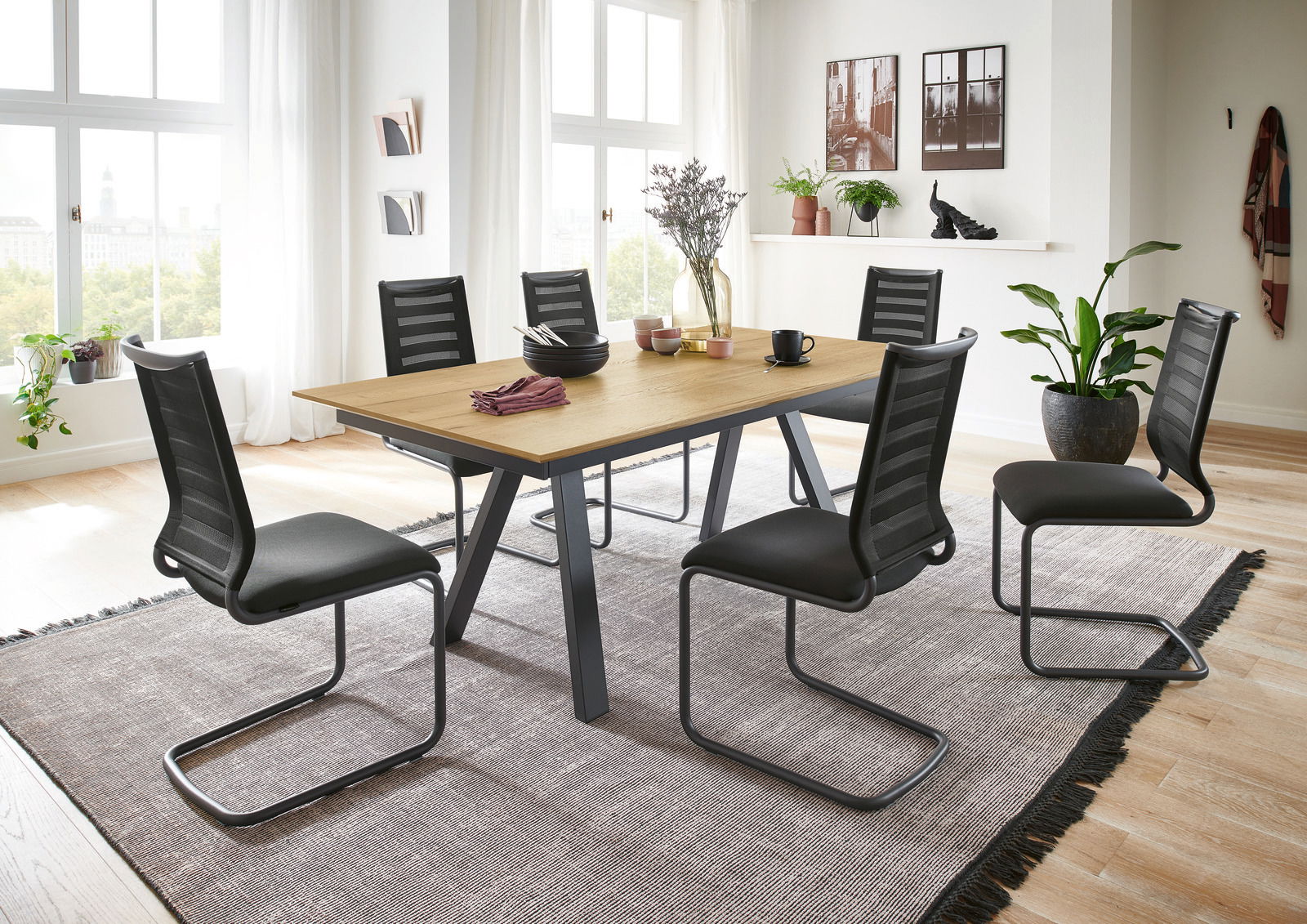 Esszimmer mit modernem Freischwinger-Stuhl-Set der Serie LILLI von Venjakob, seitliche Perspektive auf den Tisch mit sechs Stühlen, helle und einladende Raumgestaltung.