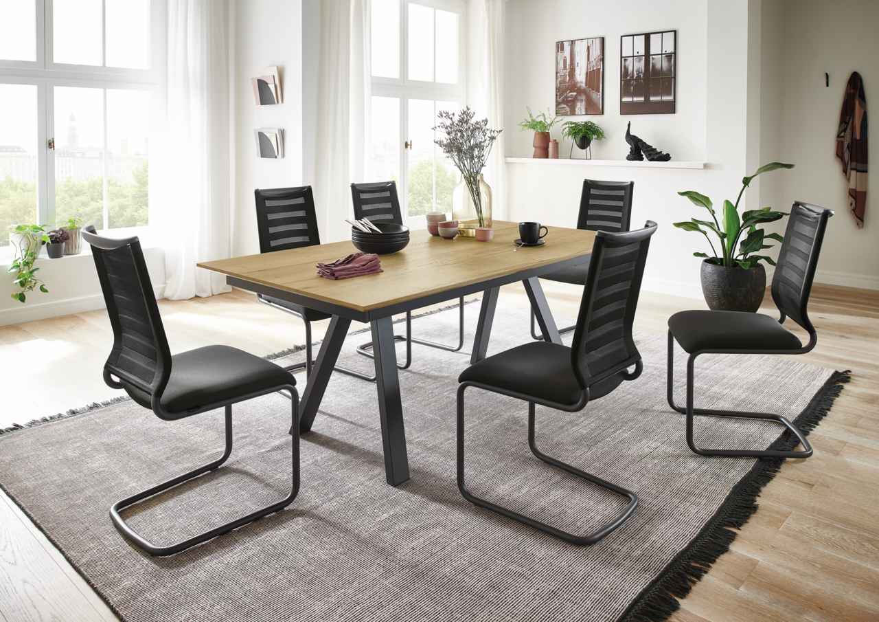 Esszimmer mit modernem Freischwinger-Stuhl-Set der Serie LILLI von Venjakob, seitliche Perspektive auf den Tisch mit sechs Stühlen, helle und einladende Raumgestaltung.