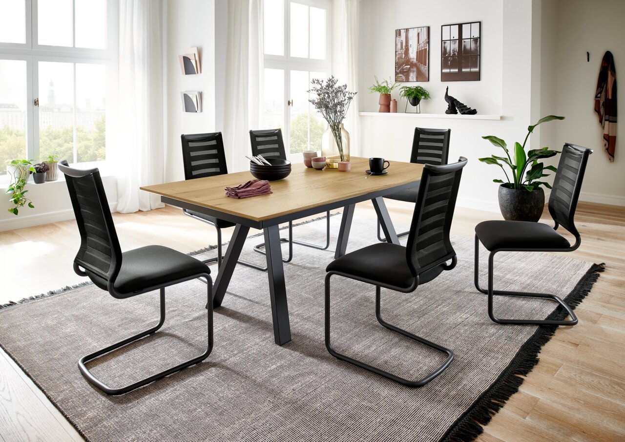 Esszimmer mit modernem Freischwinger-Stuhl-Set der Serie LILLI von Venjakob, seitliche Perspektive auf den Tisch mit sechs Stühlen, helle und einladende Raumgestaltung.