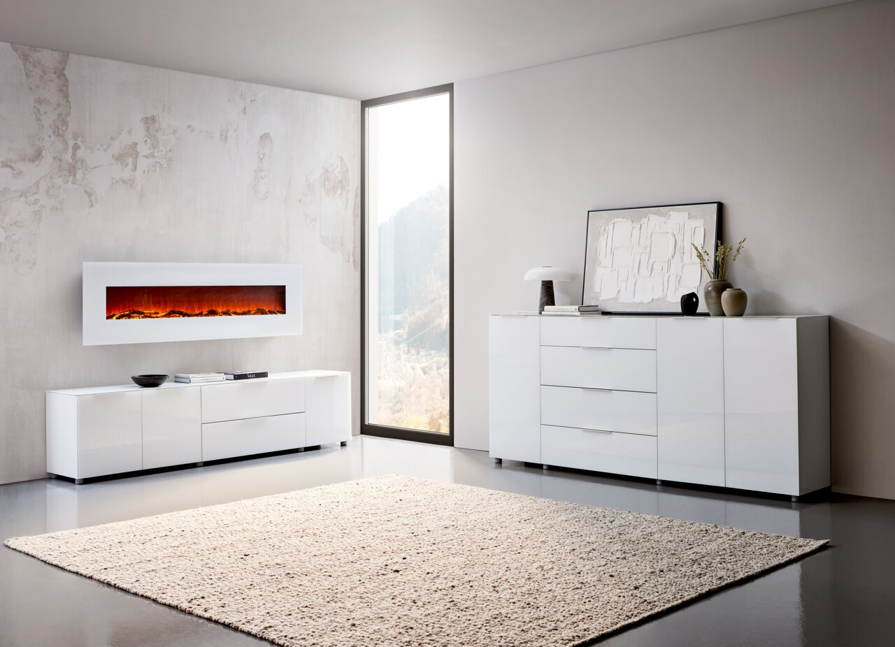 Voleo XL-Sideboard MALIN Modernes Wohnzimmer mit weißem XL-Sideboard und TV-Lowboard, seitliche Perspektive, stilvoll dekoriert mit Kunst und Pflanzen.