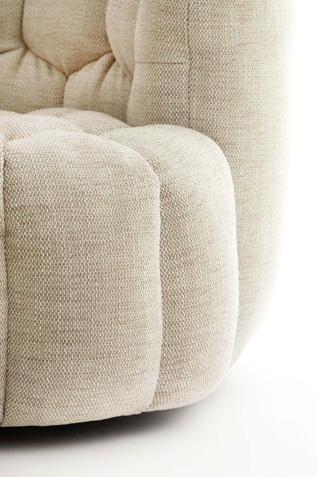 Nahaufnahme eines beigen Sessels mit strukturierter Polsterung, seitliche Perspektive