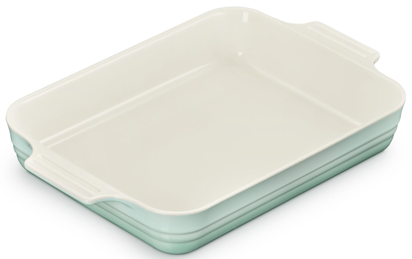 Rechteckige Keramik-Auflaufform in Mintgrün mit cremefarbener Innenfläche und seitlichen Griffen, schräg von oben in 3/4-Perspektive freigestellt auf weißem Hintergrund
