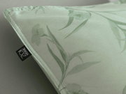 Nahaufnahme einer Bettwäsche mit floralem Muster in Grün, perspektivisch von der Ecke aufgenommen.