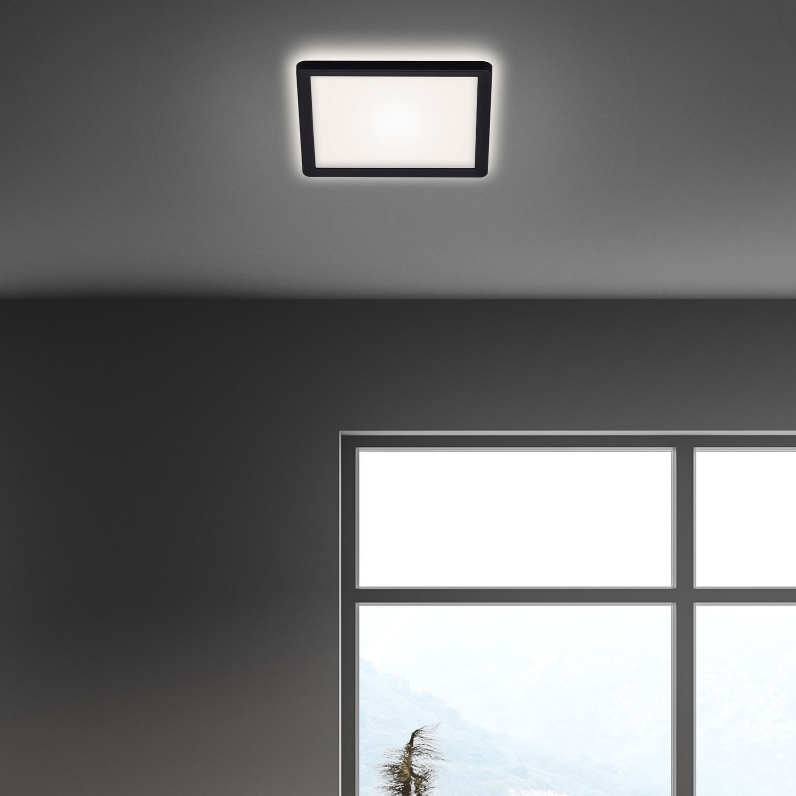 Quadratische LED-Deckenleuchte in schwarzem Rahmen, von unten betrachtet, an einer grauen Decke montiert.