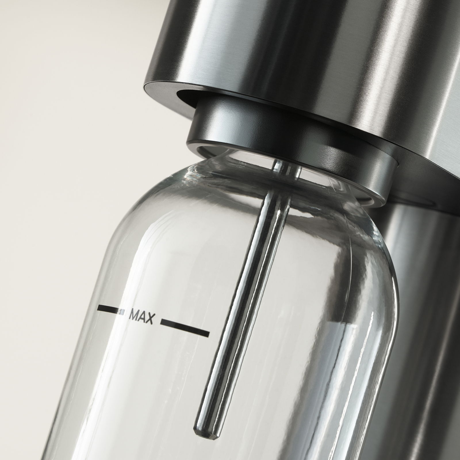 Nahaufnahme einer Wasserflasche in einem modernen Wassersprudler aus Edelstahl, seitliche Perspektive.