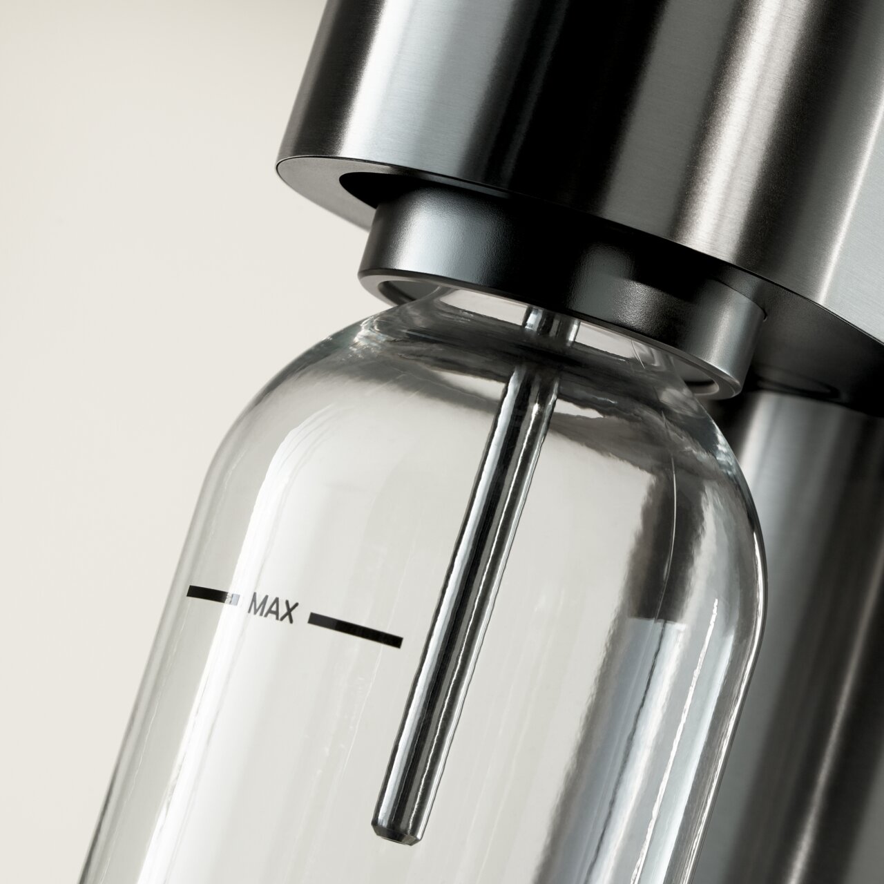 Nahaufnahme einer Wasserflasche in einem modernen Wassersprudler aus Edelstahl, seitliche Perspektive.