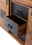 Nahaufnahme eines rustikalen Sideboards mit offenen Schubladen aus Holz und Metall, seitliche Perspektive