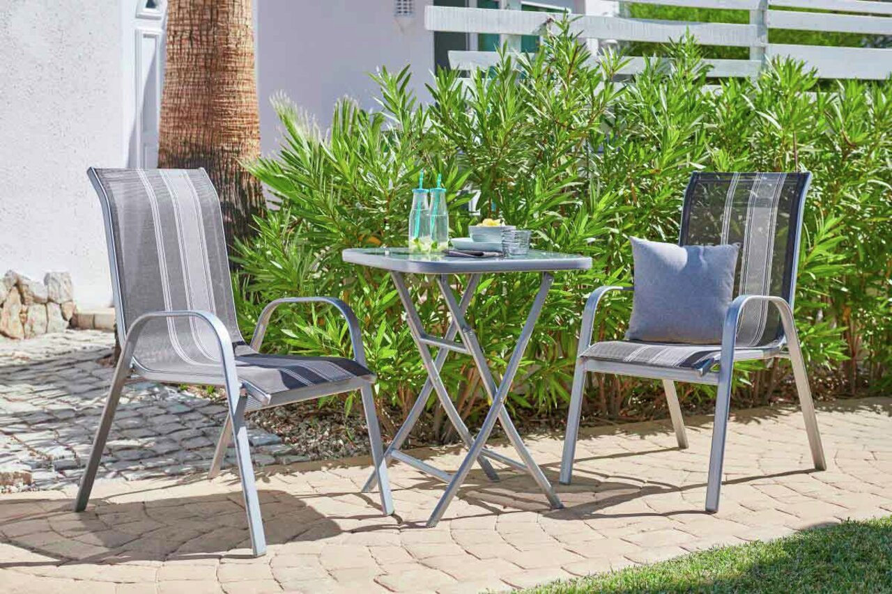 Klapptisch im Garten mit zwei Stühlen, seitliche Perspektive