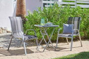 Klapptisch im Garten mit zwei Stühlen, seitliche Perspektive