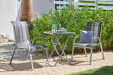 Klapptisch im Garten mit zwei Stühlen, seitliche Perspektive