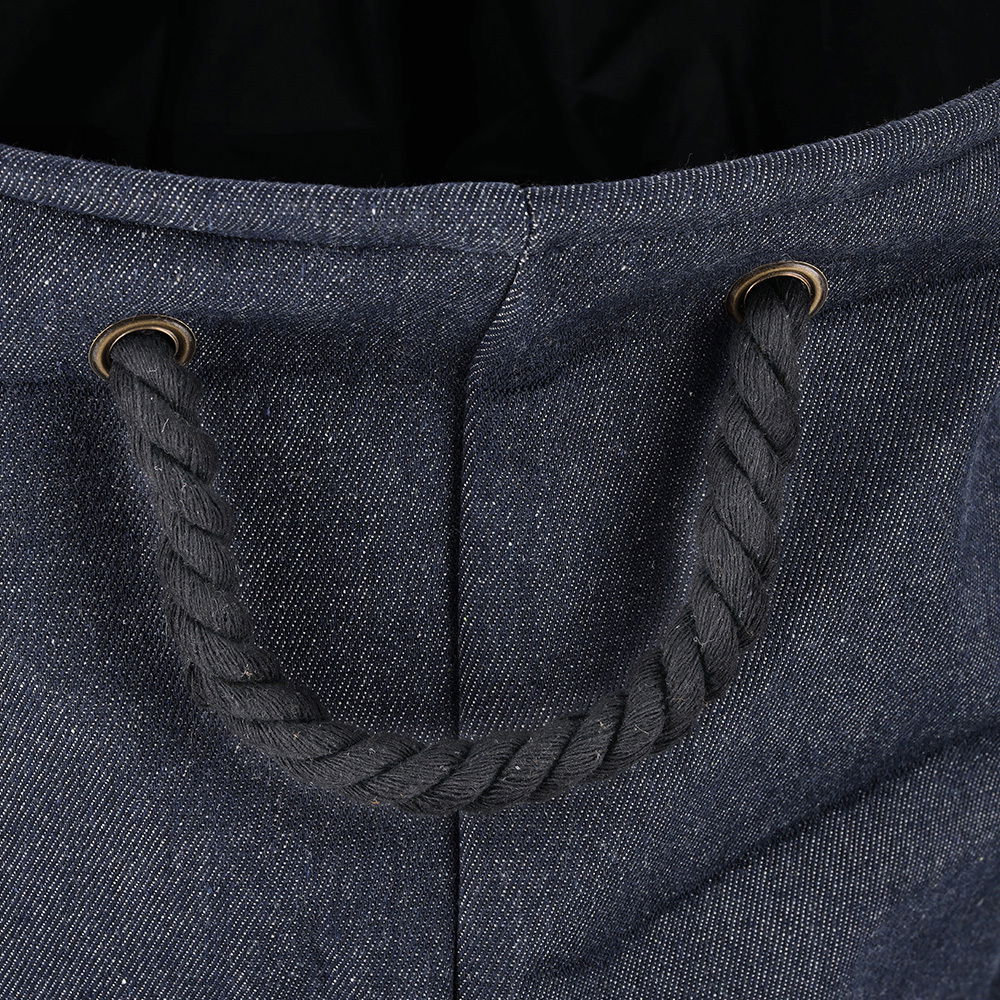 Nahaufnahme eines Wäschesammlers aus Denim-Stoff mit einem robusten Seilgriff, von oben betrachtet.