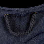 Nahaufnahme eines Wäschesammlers aus Denim-Stoff mit einem robusten Seilgriff, von oben betrachtet.