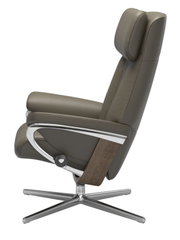Zijaanzicht van een moderne fauteuil met bruine lederen bekleding, verstelbare hoofdsteun en metalen frame.