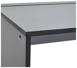 Nahaufnahme einer Ecke eines modernen Gamingtisches mit schwarzem Rahmen und grauer Tischplatte, seitliche Perspektive.