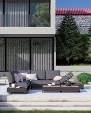 Moderne tuinmeubelset met grijze hoekbank en salontafels op een terras, gezien van voren.