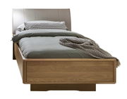 Komfortbett aus Holz mit gepolstertem Kopfteil, frontal fotografiert