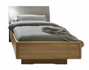 Comfortabel houten bed met gestoffeerd hoofdeinde, gefotografeerd van voren