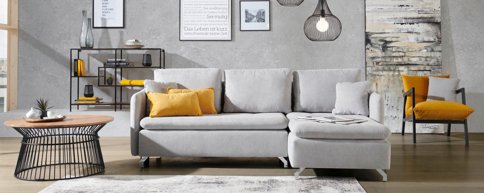 Graue Rundecke mit gelben Kissen in modernem Wohnzimmer, frontal betrachtet.