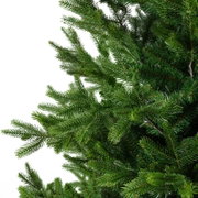 Detailansicht aus seitlicher Perspektive auf die dichten, naturgetreu gestalteten grünen Zweige eines künstlichen Weihnachtsbaums vor weißem Hintergrund