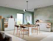 Modernes Highboard in einem stilvollen Esszimmer, mit weißem Korpus und Holzakzenten, aus der Perspektive des Raumes betrachtet.