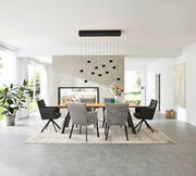 Esszimmer mit modernem Esstisch und Armlehnstühlen, frontal betrachtet. Helle, minimalistische Einrichtung mit großen Fenstern und hängender Beleuchtung.