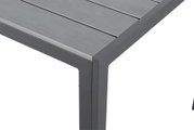 Nahaufnahme eines Gartentisches mit grauer Metalloberfläche und stabilen Beinen, Perspektive von oben.