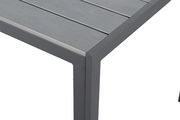 Nahaufnahme eines Gartentisches mit grauer Metalloberfläche und stabilen Beinen, Perspektive von oben.