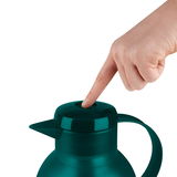 Nahaufnahme einer türkisfarbenen Isolierkanne SAMBA, auf deren Deckel eine Hand drückt.