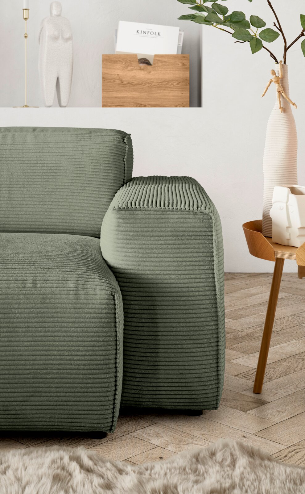 Groene hoekbank met geribbelde stoffen bekleding, gezien vanaf de zijkant, naast een houten tafel met decoraties.