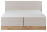 Boxspringbett in Frontalansicht mit hellgrauem Stoffbezug und Holzfußteil