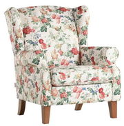 Blumiger Sessel mit hoher Rückenlehne und Holzbeinen, seitliche Perspektive