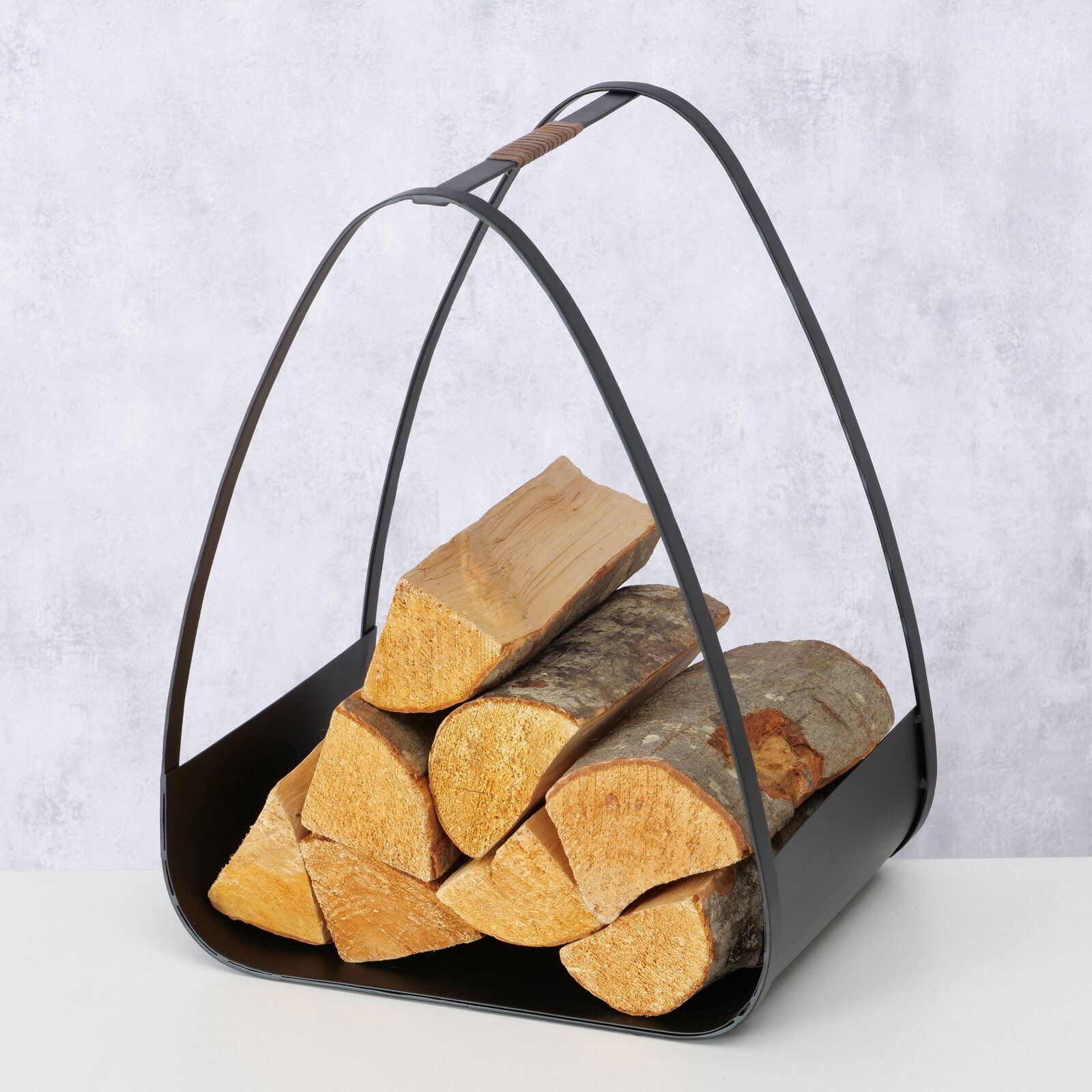 Kaminholzregal Timo, H 50 cm, aus schwarzem Metall mit Holzgriff, gefüllt mit Holzscheiten, seitliche Perspektive.