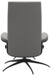 Achterkant van een grijze fauteuil met een zwart draaivoet