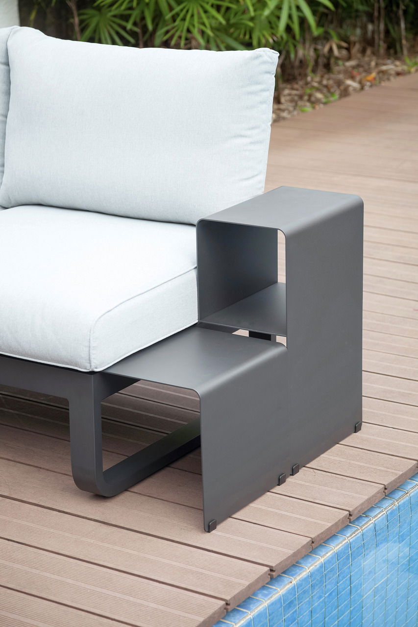 Zebra Lounge Beistelltisch FLY Moderner Lounge Beistelltisch aus Metall in anthrazitgrau, seitliche Perspektive neben einem hellen Outdoor-Sofa, auf einer Holzterrasse am Pool.