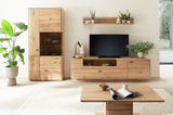 Wohnzimmeransicht mit der Linea Natura Wandkombination GEORGIA in hellem Holz, bestehend aus einem hohen Schrank, einem TV-Board und einem Wandregal, dekoriert mit Pflanzen und Keramik, aus der Perspektive von vorne.