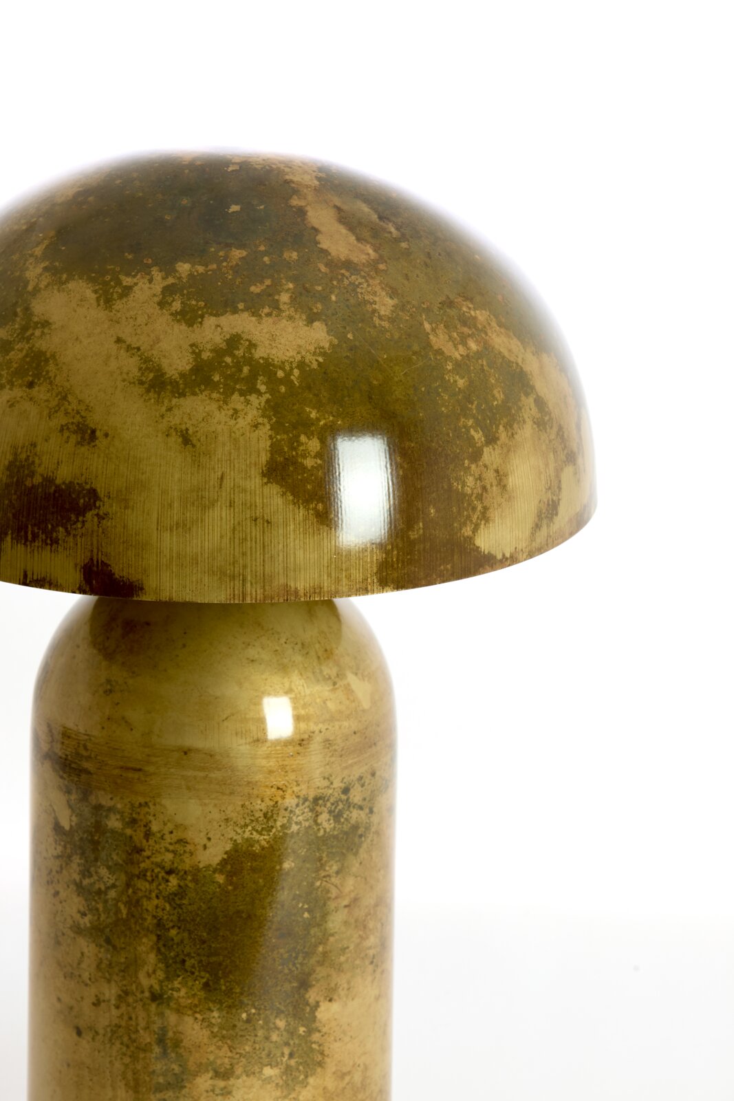Close-up vanuit vooraanzicht van een goudkleurige metalen tafellamp met koepelvormige kap en een karakteristieke verweerde patina-afwerking.